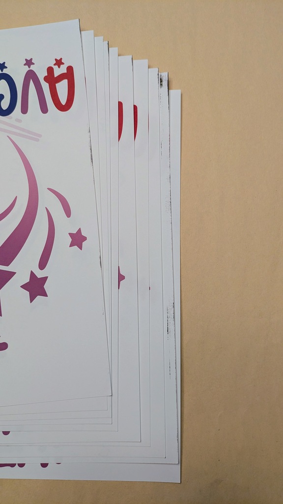 A series of 10 prints arranged to show the leading edge of the prints. Five have visible ink on the leading edge with one having a nearly .2" streak along its top edge.